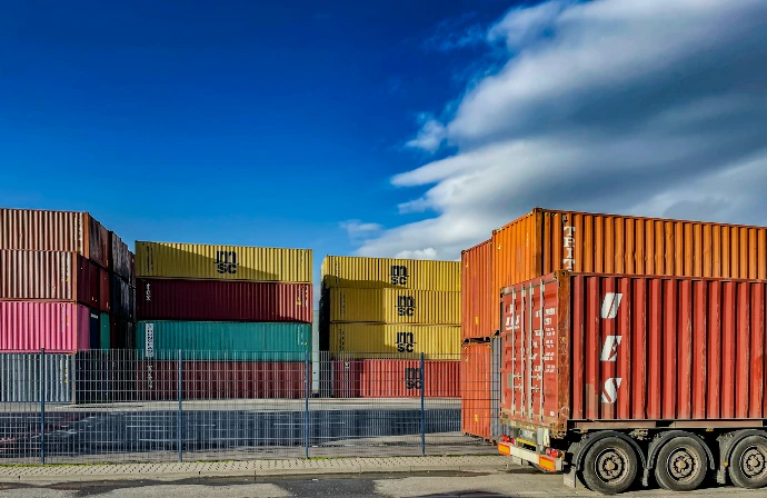 a truck is parked in front of a bunch of shipping containers